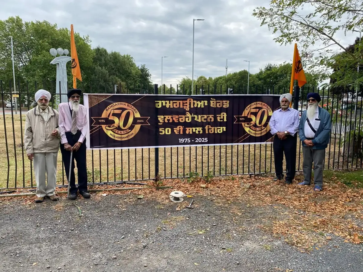 Members of the sangat beside the Golden Jubilee banner outside the Gurdwara