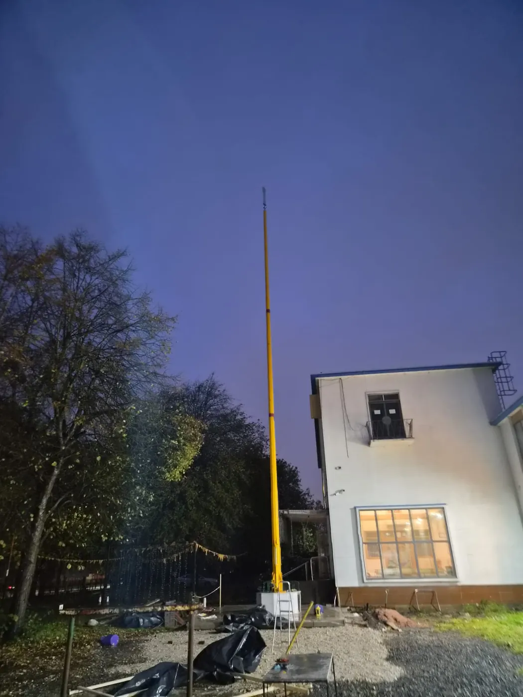 The newly raised Nishan Sahib beside the Gurdwara at dusk