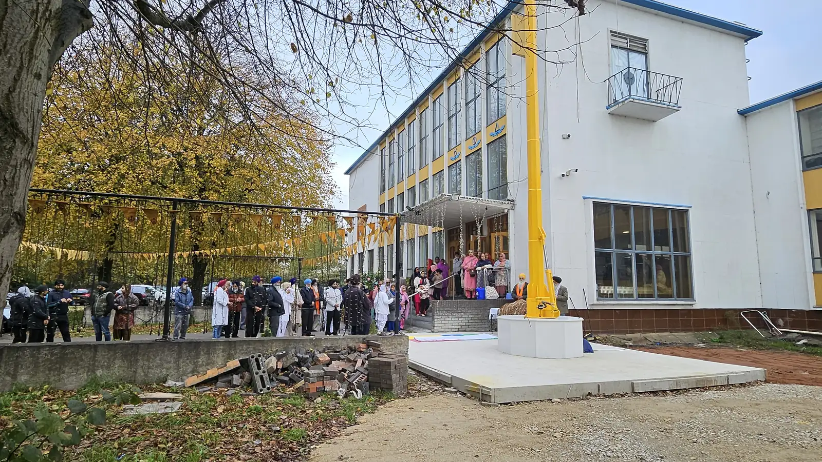 The sangat gathered in front of the Gurdwara beside the Nishan Sahib